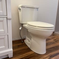 White toilet installed on wood-look flooring in bathroom