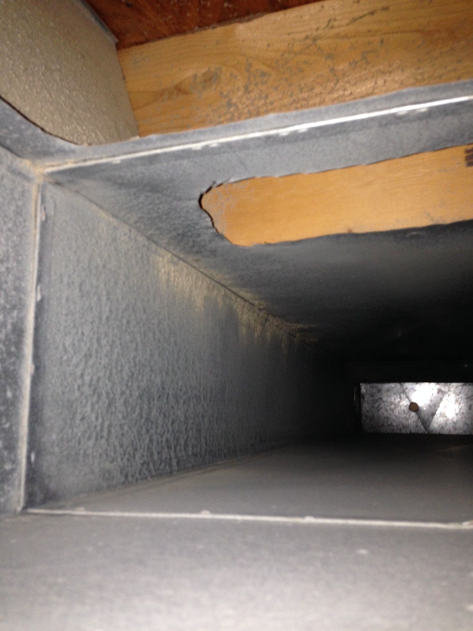 Interior of damaged metal ductwork with torn insulation and exposed seam